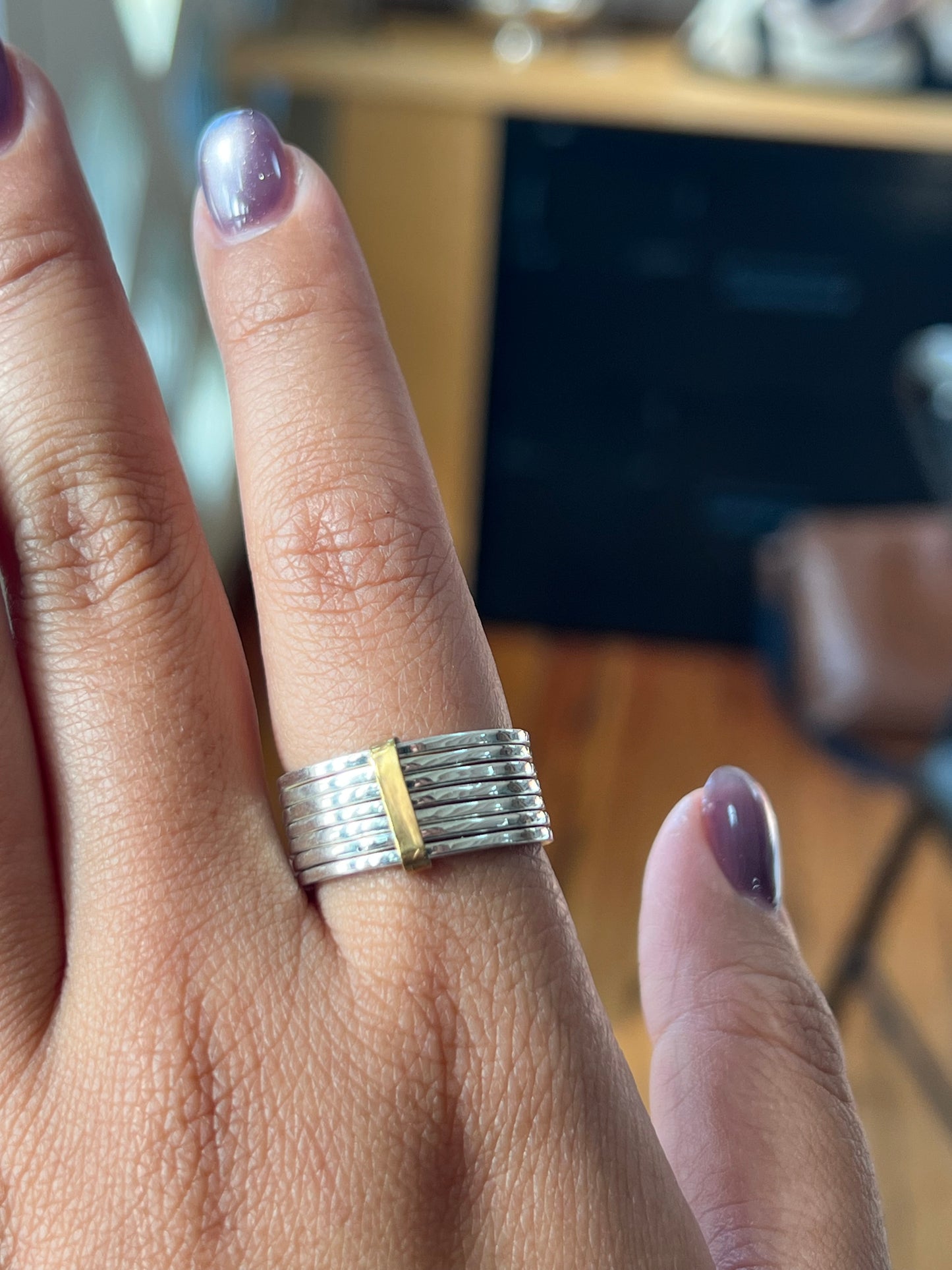 Hand wearing a silver ring with gold accent