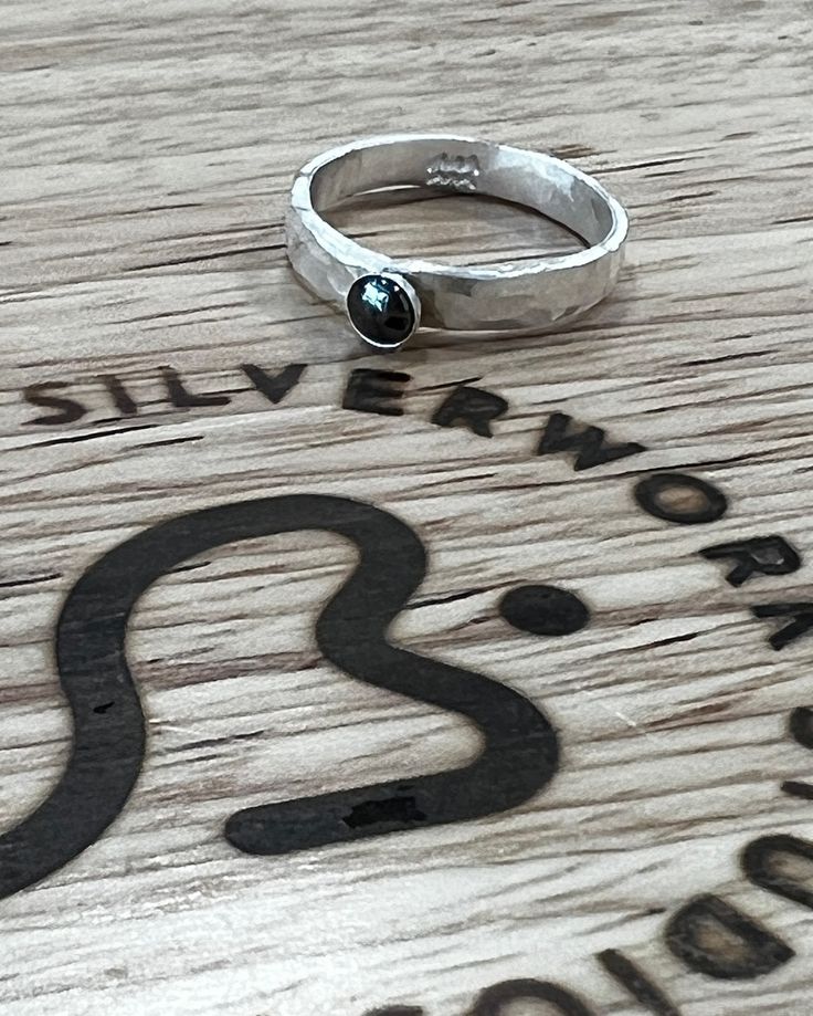 Thick hammered silver band ring with small gemstone